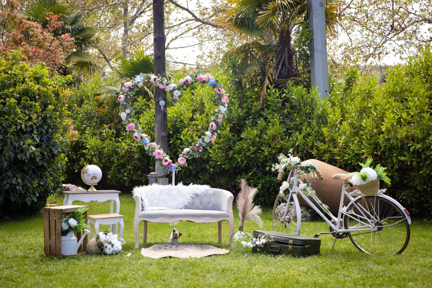 Rincón decorado con corazón floral, sofá vintage y bicicleta en Finca La Peraleña
