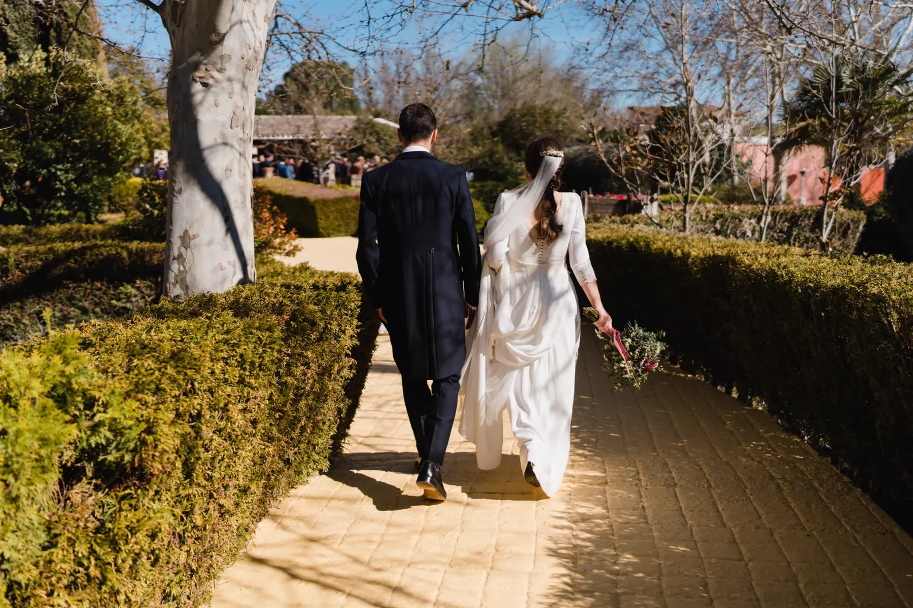 Novios paseando entre setos recortados por los jardines de Finca La Peraleña