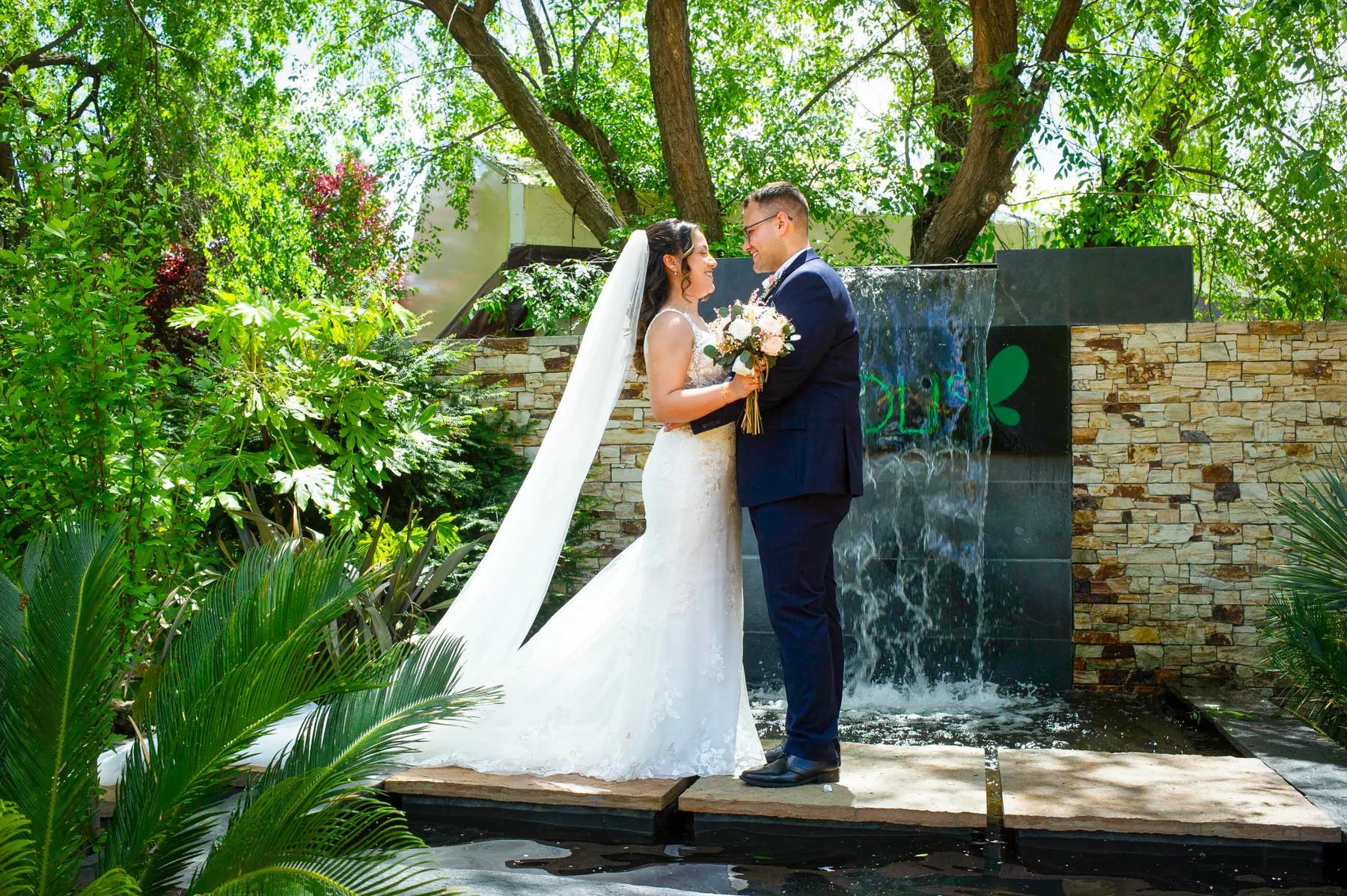 Novios junto a la cascada de agua del jardín de Espacio Éboli