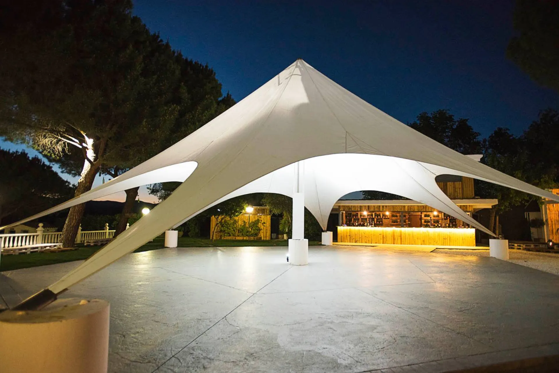 Carpa estrella iluminada en el exterior nocturno de Finca Quinta La Galana
