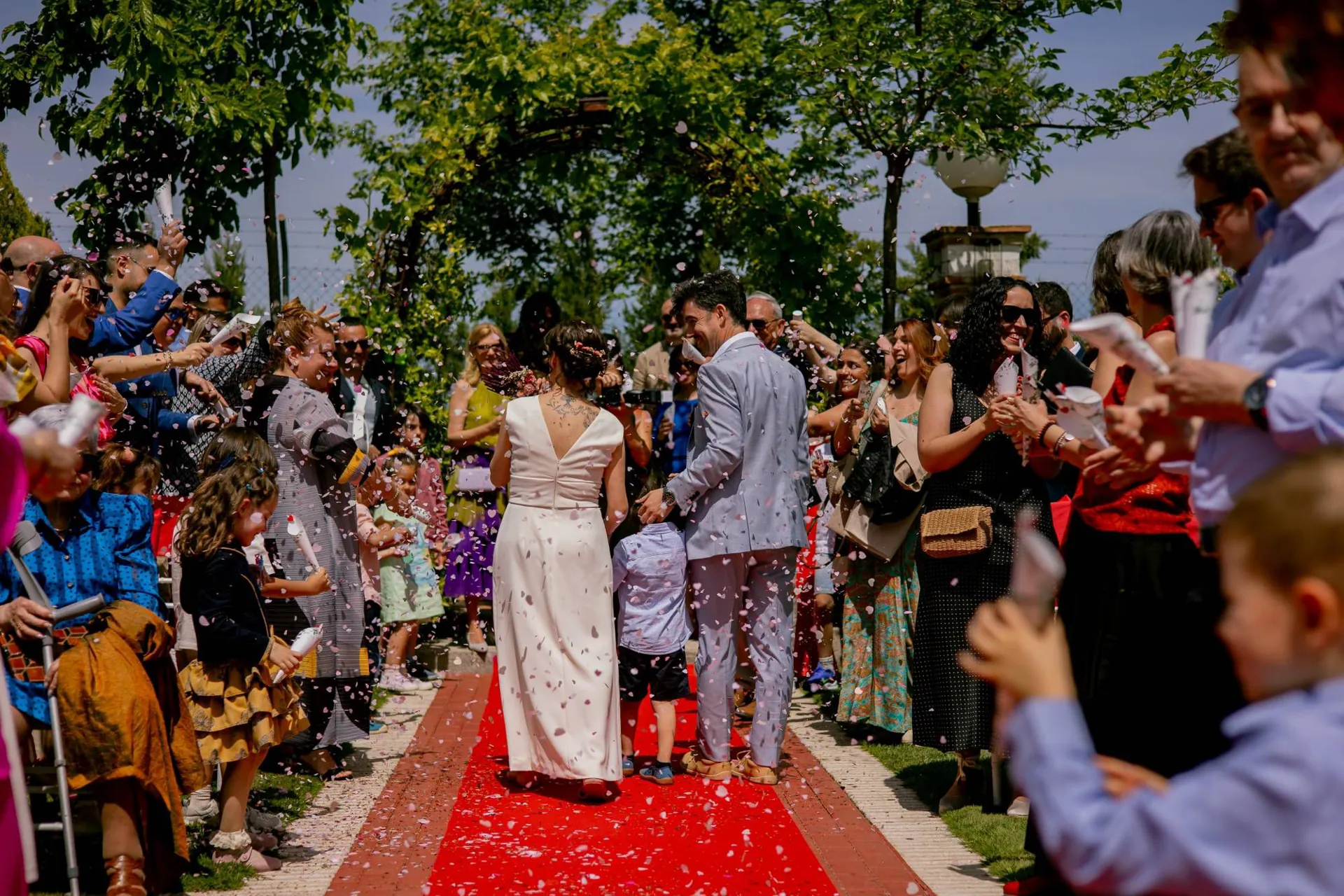 Novios saliendo de la ceremonia entre pétalos en Finca Los Rosales de Cubas