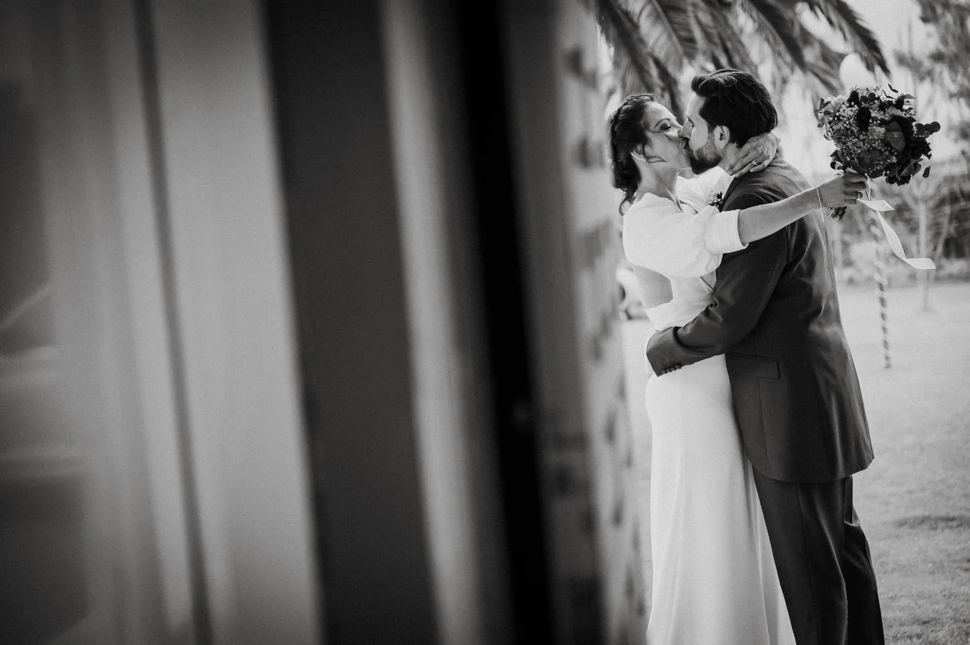 Novios besándose en blanco y negro durante su boda