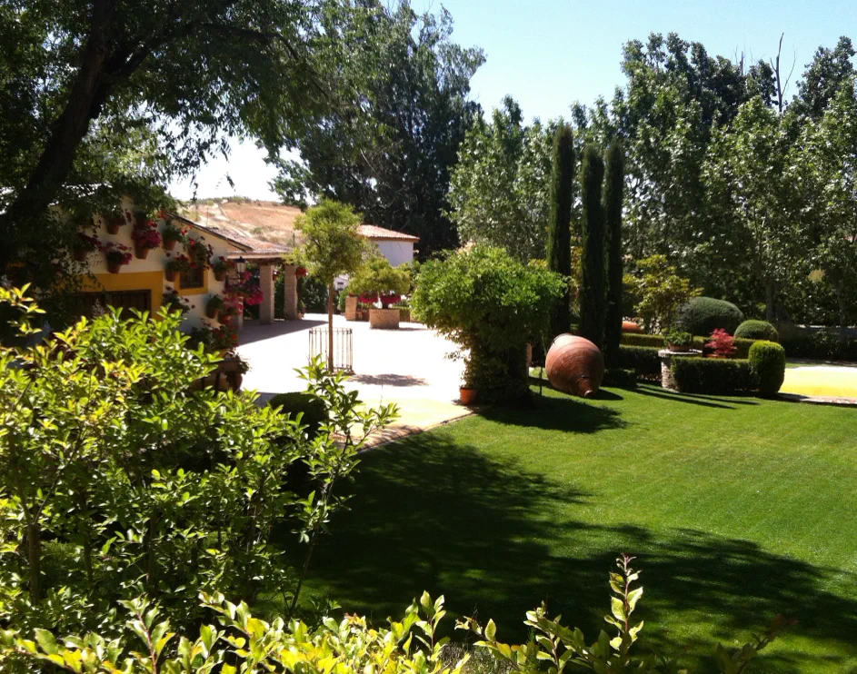 Jardín soleado con cipreses y anfora de Finca La Peraleña