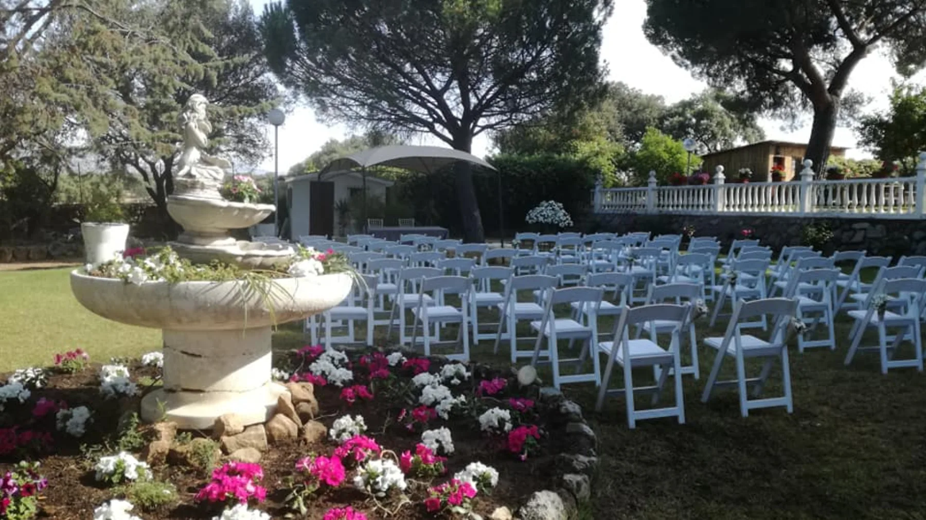 Jardín con fuente y sillas blancas preparadas para la ceremonia en Finca Quinta La Galana