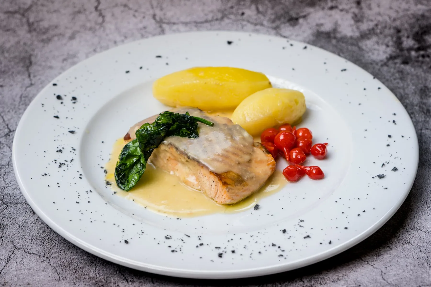 Salmón con salsa de vino blanco, espinacas y patatas emplatado en Finca Los Rosales de Cubas