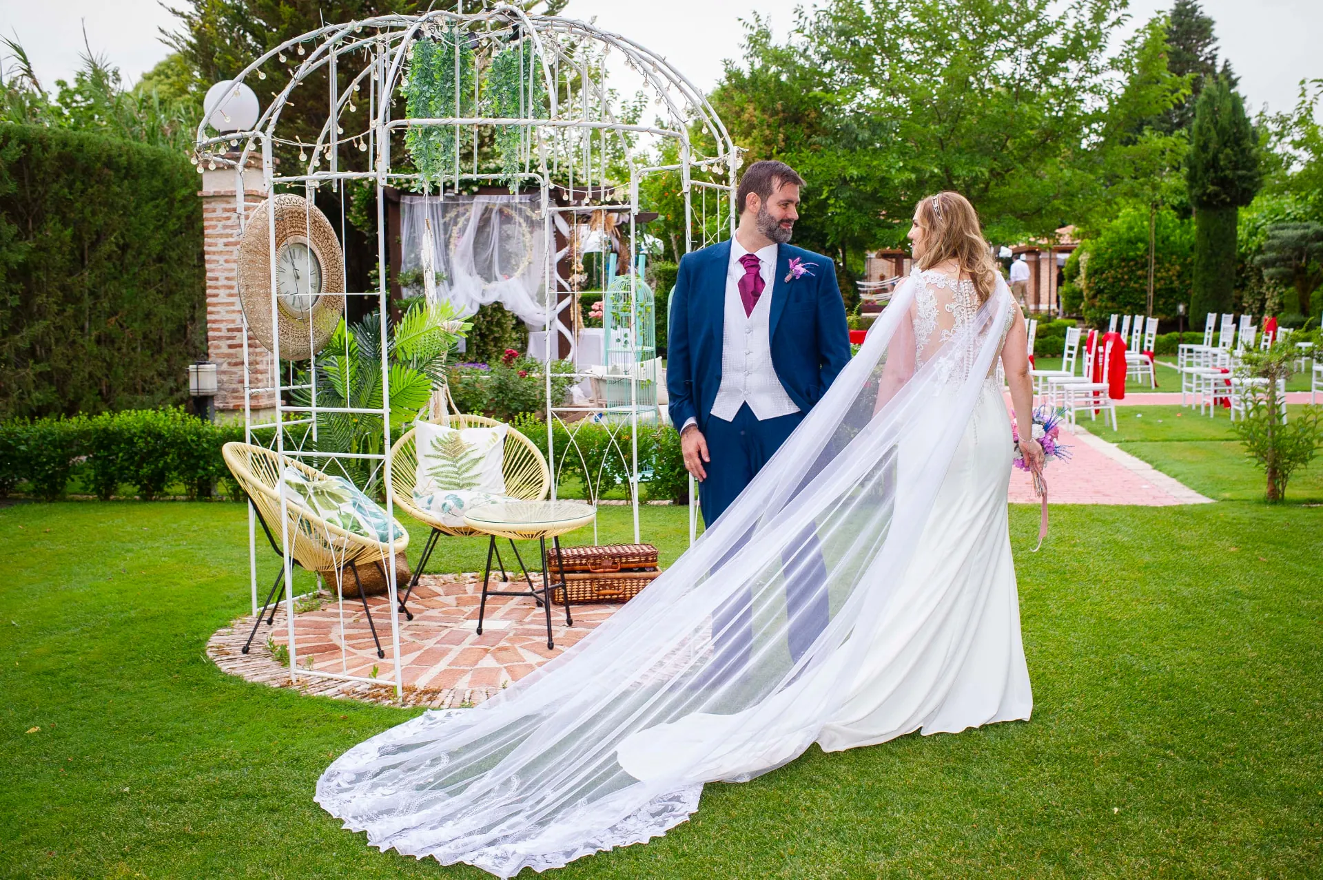 Novios con velo largo en el jardín de Finca Los Rosales de Cubas