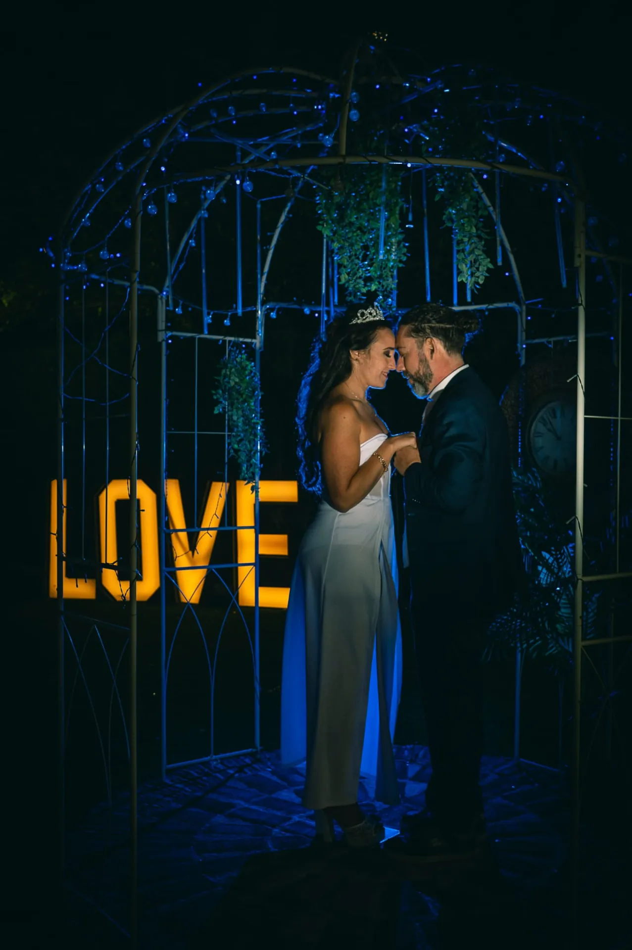Novios bailando de noche junto a las letras LOVE en Finca Los Rosales de Cubas