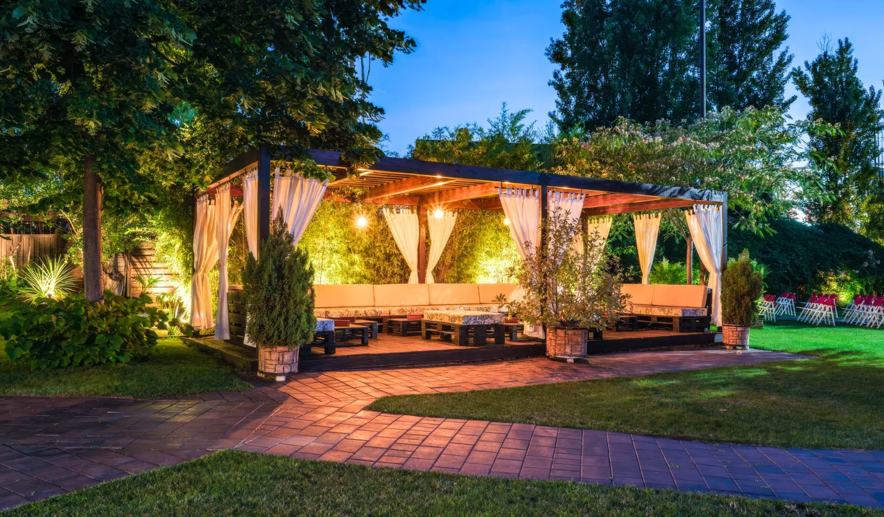 Pérgola con zona chill out iluminada al anochecer en Espacio Éboli