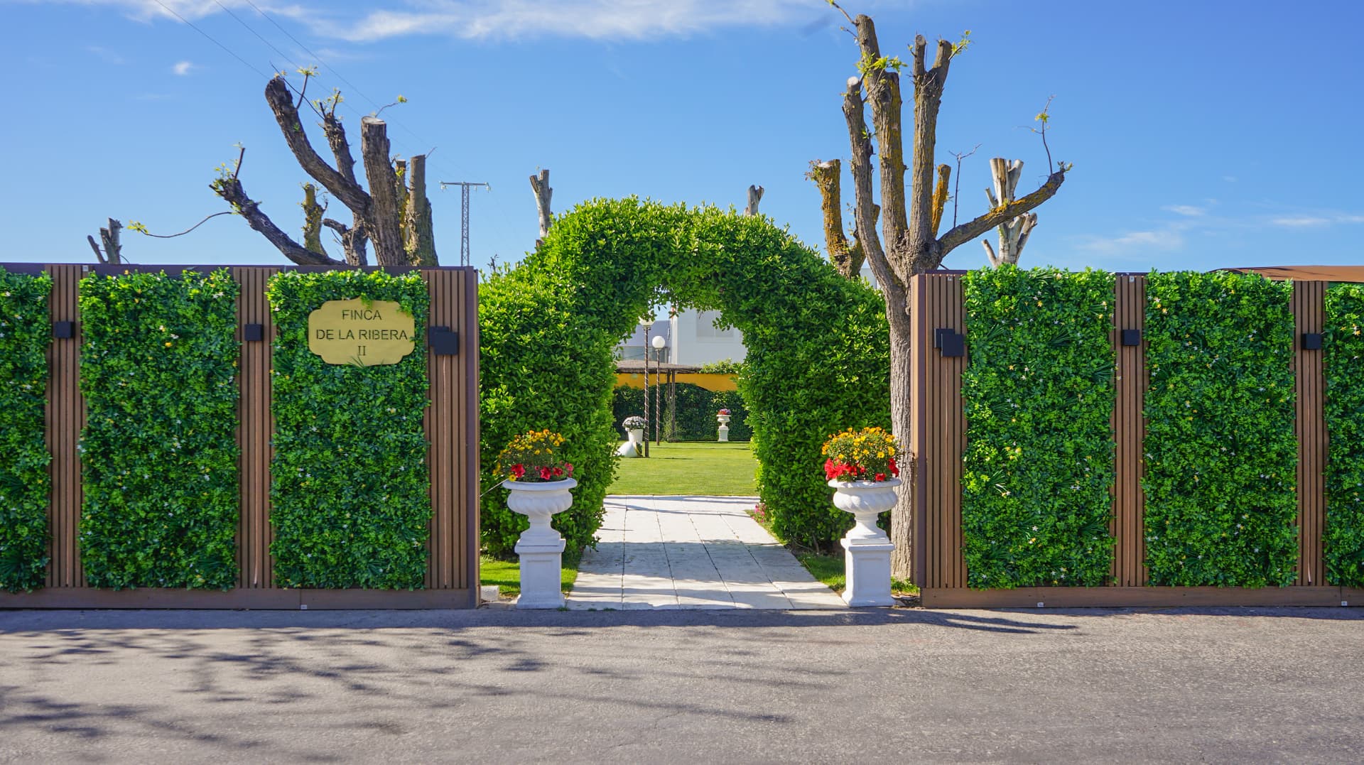 Entrada de una finca para bodas en la Comunidad de Madrid, con arco de setos y jardín preparado para una celebración